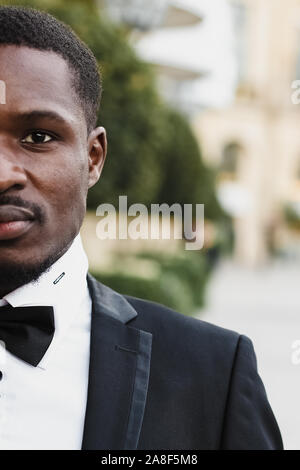 Afro american man wearing suit and standing near building Stock Photo ...