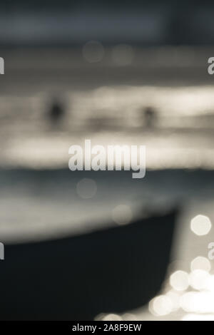 An enigmatic view of a boat prow against a blurred  background with interesting lighting. Suitable for a book cover with space for text. Stock Photo