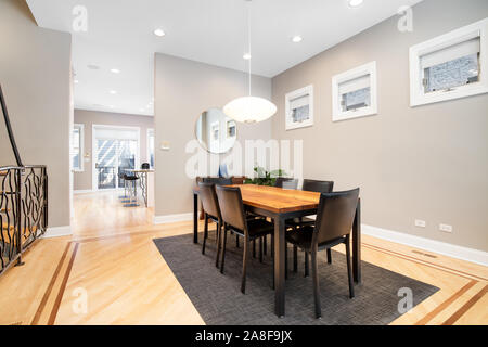 A luxurious dining room area that connects to the living room. This spacious area can fit a large table with a modern light hanging down over the top. Stock Photo