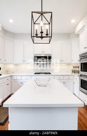 A modern farmhouse kitchen with white cabinets, a wood island with chairs,  Viking stainless steel appliances, and a dark granite countertop Stock  Photo - Alamy