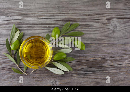 Olive oil and olive branch on wooden table Stock Photo