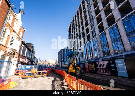 A JCB driver works on the new Hilton Hotel building, structure in Stoke on Trent, Hanley, loading and unloading materials for his work colleagues Stock Photo