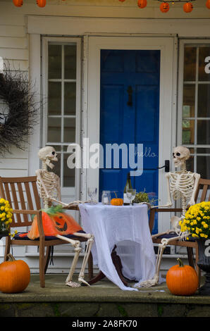 Two Skeletons couple sitting a dining table having wine for Halloween romantic date night, Yarmouth, Maine, USA Stock Photo