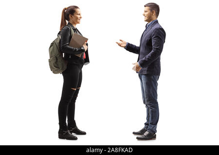 Full length profile shot of a female student having a conversation with a young man isolated on white background Stock Photo