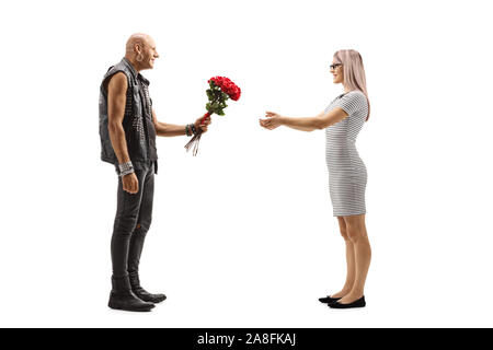 Full length shot of a punker giving flowers to a young woman isolated on white background Stock Photo