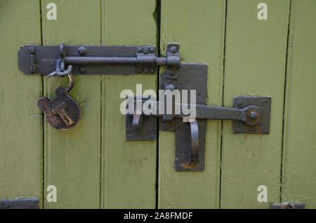 Keep out: A handmade wrought Iron lock and handle on an antique wooden door that is painted green, Stourhead garden, Wiltshire UK Stock Photo