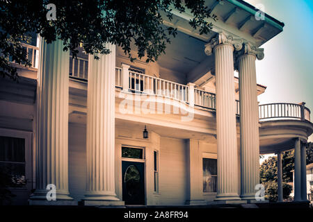Ionic columns and a round veranda are highlights of this Greek Revival style antebellum home in the historic neighborhood of Hattiesburg, MS, USA Stock Photo