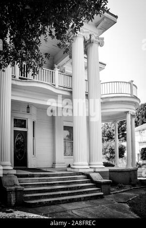 Ionic columns and a round veranda are highlights of this Greek Revival style antebellum home in the historic neighborhood of Hattiesburg, MS, USA Stock Photo