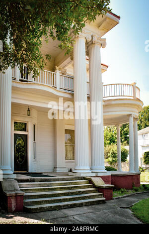 Ionic columns and a round veranda are highlights of this Greek Revival style antebellum home in the historic neighborhood of Hattiesburg, MS, USA Stock Photo