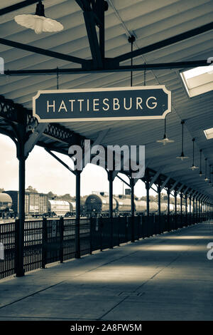 Overhead canopy for Passengers waiting area for boarding at the Hattiesburg, MS, train depot, with nameplate sign and oil tankers nearby, Hattiesburg, Stock Photo