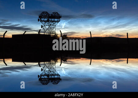 Noctilucent clouds shining brightly over a communications mast on the east Lancashire / North Yorkshire borders near Skipton. Stock Photo