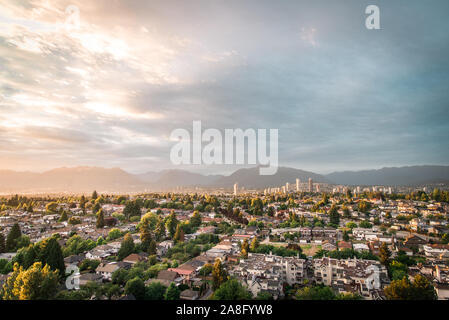 View of East Vancouver and Brentwood, Burnaby skylines with mountains backdrop during and epic summer sunset Stock Photo