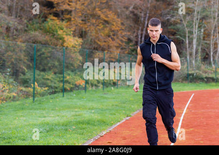 Young man jogging in the morning outdoor on the running race track Stock Photo