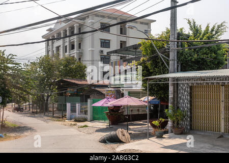 Nha Trang, Vietnam - March 11, 2019: Roadside coffee shop in rural area with large office building as neighbor and thick communications and electrical Stock Photo