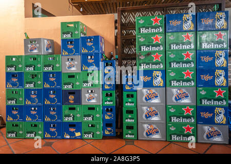 Nha Trang, Vietnam - March 11, 2019: Wall of green Heineken and blue Tiger beer crates, stands on red tiled floor. Stock Photo