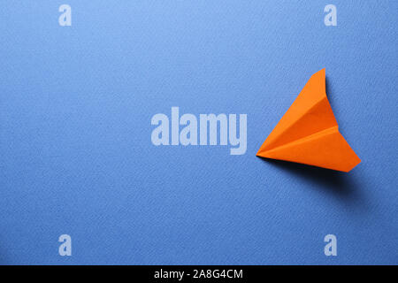 Orange paper plane on blue background Stock Photo