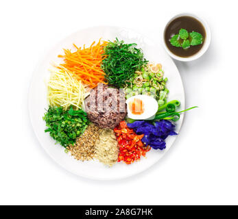 Rice Salad with vegetables and budu fish sauce  (Khao Yum) Thai Southern Spicy style side view Stock Photo