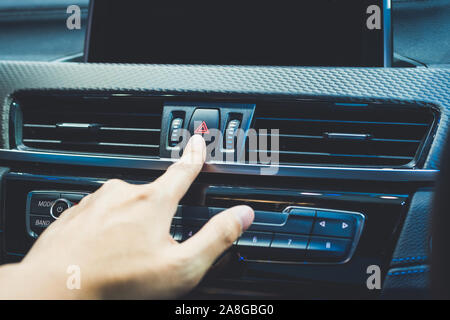 Presses the emergency stop in the car by hand of man Stock Photo