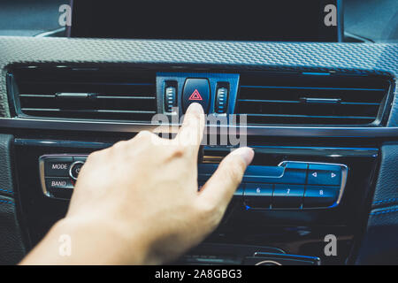 Presses the emergency stop in the car by hand of man Stock Photo