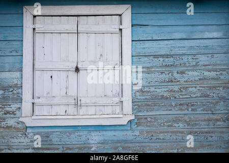 Closed on lock White window on wooden old blue wall Stock Photo