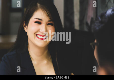 Portrait of smiling female candidate during corporate meeting or job interview with businesswoman holding resume and talking interview - business, car Stock Photo