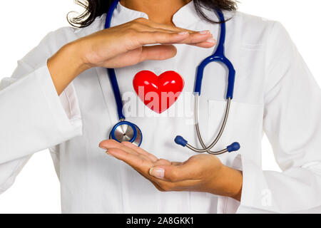 Eine junge Ärztin (Internistin) hält ein Herz symbolisch in der Hand. Stock Photo