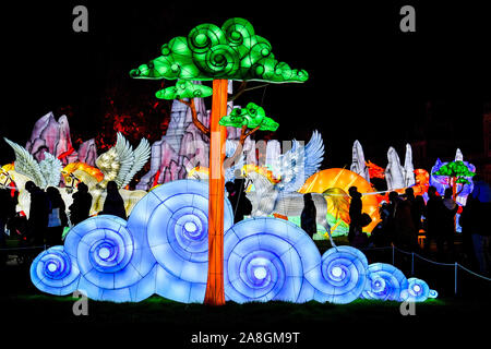 Clouds and trees are illuminated in the Festival of Light, featuring sculptures on the themes of myths and legends from across the world, at Longleat House, Wiltshire. Stock Photo