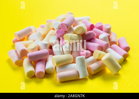 Multi-colored little marshmallows on a bright yellow background. Stock Photo