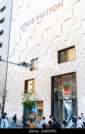 The exterior of the Ginza Louis Vuitton building with people walking by on a springtime weekend when the street becomes a pedestrian precinct. Daytime Stock Photo