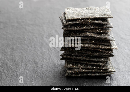 Black  Rye Sourdough Crispbread on black stone table Stock Photo