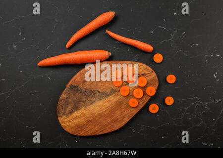 Flat lay photo, carrots some sliced to small circles on cutting board Stock Photo