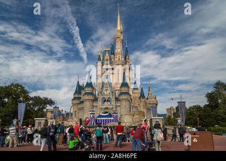 Cinderella's castle in Magic kingdom Orlando, Florida daylight view with people in foreground and clouds in sky in background Stock Photo