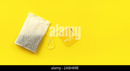 Top down view, tea bag on yellow board, wide banner with space for text on right side Stock Photo