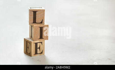 Pile with three wooden cubes - word LIE on them, space for more text / images at right side. Stock Photo