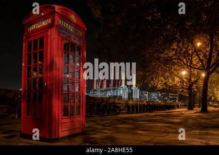 Battersea Power Station at night with a red telephone box in the foreground Stock Photo