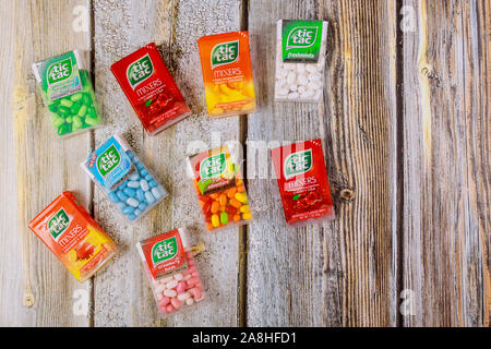 New York NY NOV 08 2019: Candies variety of Tic Tac in the mint boxes of packages on old wood background Stock Photo