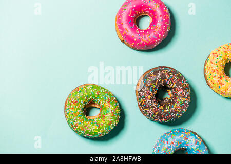 Group of glazed donuts on blue background, copy space Stock Photo