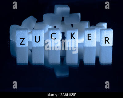sugar cubes on top another in front of different colors Stock Photo