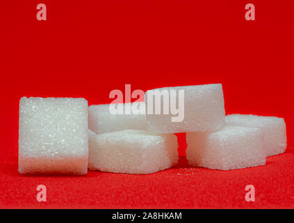 sugar cubes on top another in front of different colors Stock Photo