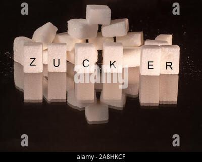 sugar cubes on top another in front of different colors Stock Photo