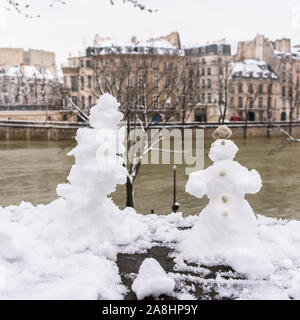Paris under the snow and floods, snowman on the bank of the Seine, beautiful building facades in winter Stock Photo