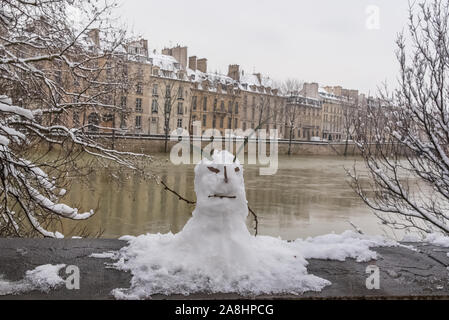 Paris under the snow and floods, snowman on the bank of the Seine, beautiful building facades in winter Stock Photo