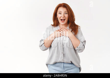 Such pleasant surprise darling. Amused excited middle-aged lucky optimistic redhead woman smiling broadly hands chest appreciation gladly receive gift Stock Photo