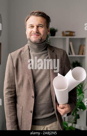Successful engineer or architect in formalwear holding rolled blueprints Stock Photo