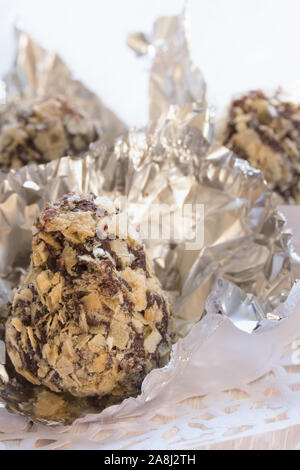 candies in chocolate and crushed wafers on a white wooden table Stock Photo