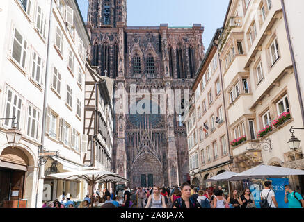 Strasbourg, Bas-Rhin / France - 10 August 2019: view of the Strasbourg Cathedral and many tourists on the Rue Merciere street in high summer Stock Photo