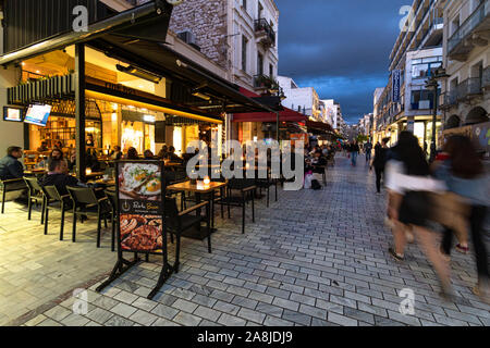 Patras, Greece - May 1 2019: People, captured with blurred motion, walk in the cobblestone street of Patras old town in Greece Stock Photo
