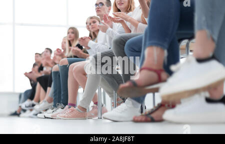 group of diverse young people sitting in a row Stock Photo