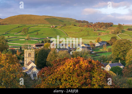 St. Wilfrid's Church is visible amongst the rich tones of autumn foliage in the quaint village of Burnsall, Yorkshire Dales National Park. Stock Photo