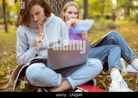 Hungry girl having her lunch in the park Stock Photo